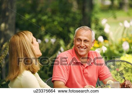 Picture - Mature man smiling with a mid adult woman. Fotosearch