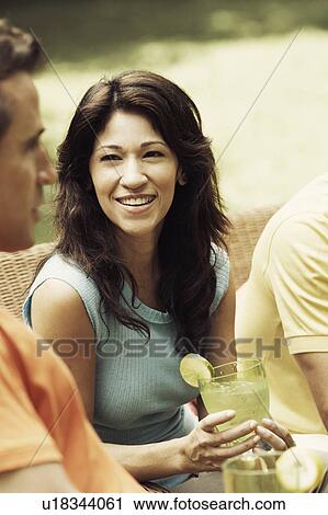 Stock Image - Mature woman holding a glass of lemonade. Fotosearch