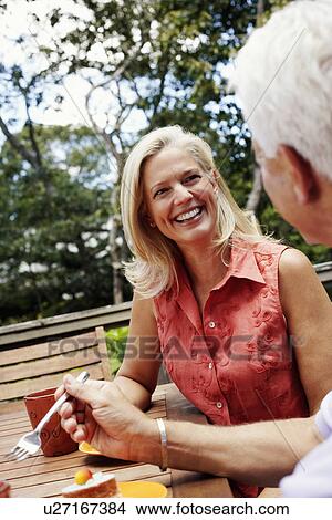 Mature woman looking at a mature man and smiling View Large Photo Image Picture - Mature woman looking at a mature man and smiling. Fotosearch