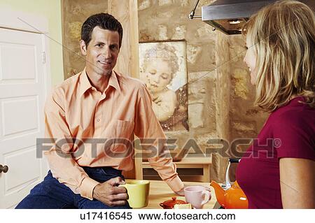 Stock Photography - Portrait of a mature man holding a cup with a mature woman standing beside him. Fotosearch