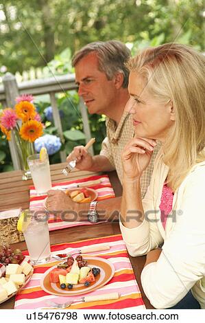 Side profile of a mature couple sitting at the table View Large Photo Image Stock Photo - Side profile of a mature couple sitting at the table. Fotosearch