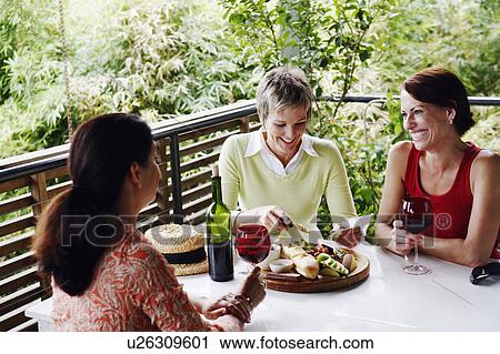 Three mature women sitting at the table and smiling View Large Photo Image Stock Image - Three mature women sitting at the table and smiling. Fotosearch