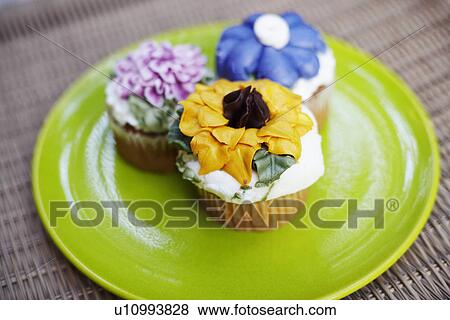 Close-up of three cupcakes on a plate View Large Photo Image Stock Photo - Close-up of three cupcakes on a plate. Fotosearch