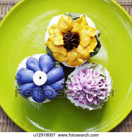 Stock Photo - Close-up of three cupcakes on a plate. Fotosearch