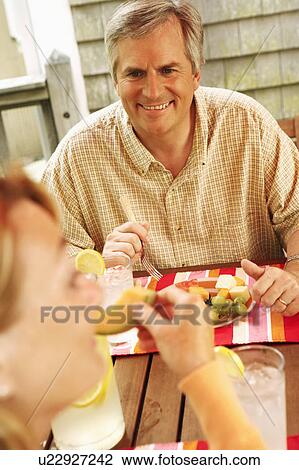 Mature man and a woman sitting at the table View Large Photo Image Stock Image - Mature man and a woman sitting at the table. Fotosearch
