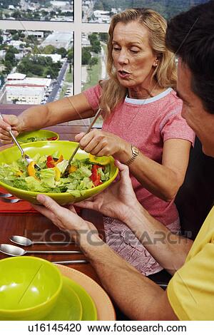 Mature woman taking salad from a bowl View Large Photo Image Stock Image - Mature woman taking salad from a bowl. Fotosearch