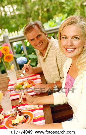 Stock Photo - Portrait of a mature couple sitting at the table. Fotosearch