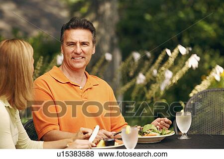 Portrait of a mature man with a mid adult woman sitting at the table View Large Photo Image Stock Photo - Portrait of a mature man with a mid adult woman sitting at the table. Fotosearch