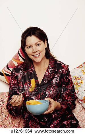 Portrait of a mature woman eating papaya with a fork View Large Photo Image Picture - Portrait of a mature woman eating papaya with a fork. Fotosearch