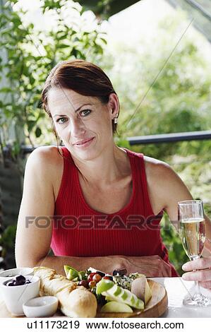 Portrait of a mature woman sitting at a table and smiling View Large Photo Image Stock Photo - Portrait of a mature woman sitting at a table and smiling. Fotosearch