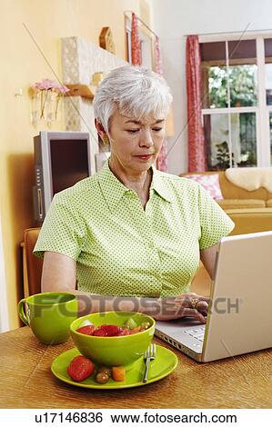 Stock Photograph - Senior woman using a laptop. Fotosearch