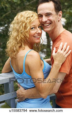 Picture - Portrait of a mature couple embracing each other and smiling. Fotosearch