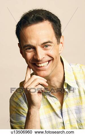 Portrait of a mature man smiling with his hand on his chin View Large Photo Image Stock Image - Portrait of a mature man smiling with his hand on his chin. Fotosearch