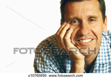 Stock Photography - Portrait of a mature man smiling with his head on his chin. Fotosearch