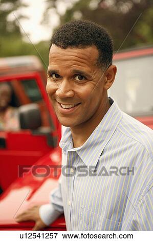 Portrait of a mature man standing near a car and smiling View Large Photo Image Stock Photo - Portrait of a mature man standing near a car and smiling. Fotosearch