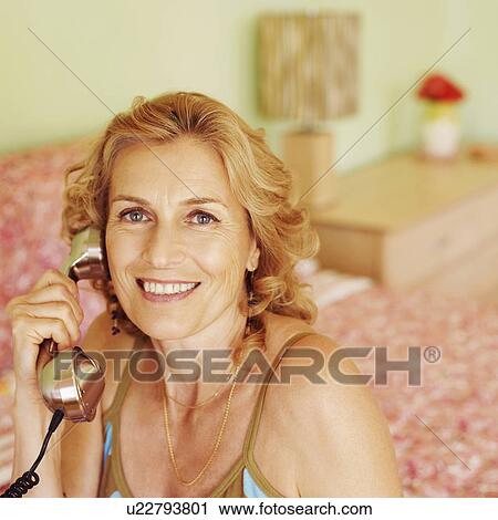 Portrait of a mature woman talking on the telephone View Large Photo Image Stock Image - Portrait of a mature woman talking on the telephone. Fotosearch