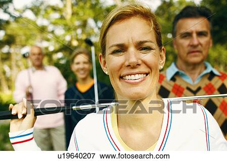 Portrait of a mid adult woman holding a golf club and smiling View Large Photo Image Stock Photo - Portrait of a mid adult woman holding a golf club and smiling. Fotosearch