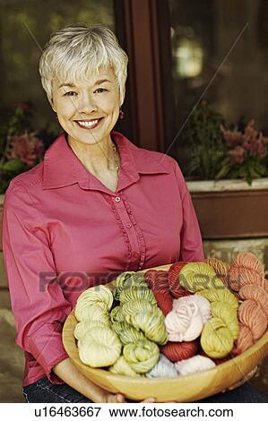 Portrait of a senior woman sitting and holding a bowl of woolen balls View Large Photo Image Stock Photo - Portrait of a senior woman sitting and holding a bowl of woolen balls. Fotosearch