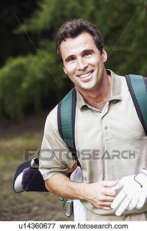 Stock Photo - Close-up of a mature man carrying a golf bag. Fotosearch