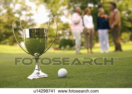 Stock Image - Close-up of a trophy and a golf ball. Fotosearch