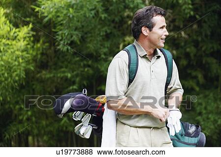 Stock Photo - Mature man carrying a golf bag. Fotosearch