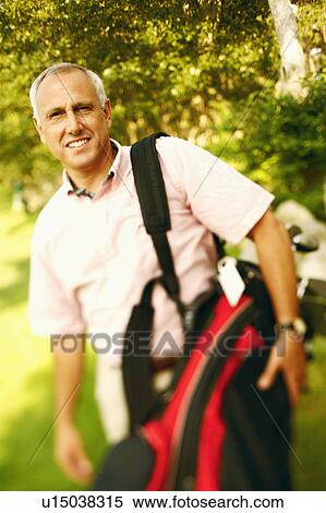 Portrait of a mature man carrying a golf bag and smiling View Large Photo Image Stock Photography - Portrait of a mature man carrying a golf bag and smiling. Fotosearch