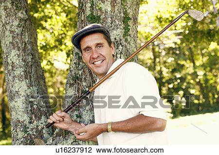 Portrait of a mature man holding a golf club and a golf ball View Large Photo Image Stock Image - Portrait of a mature man holding a golf club and a golf ball. Fotosearch