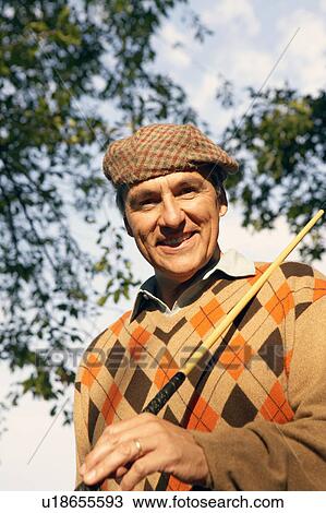 Portrait of a mature man holding a golf club and smiling View Large Photo Image Stock Image - Portrait of a mature man holding a golf club and smiling. Fotosearch