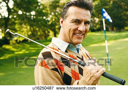Portrait of a mature man holding a golf club View Large Photo Image Stock Photo - Portrait of a mature man holding a golf club. Fotosearch
