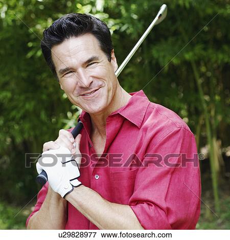 Portrait of a mature man holding a golf club and smiling View Large Photo Image Stock Photo - Portrait of a mature man holding a golf club and smiling. Fotosearch