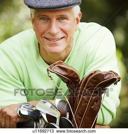 Portrait of a mature man leaning on a golf bag and smiling View Large Photo Image Stock Image - Portrait of a mature man leaning on a golf bag and smiling. Fotosearch