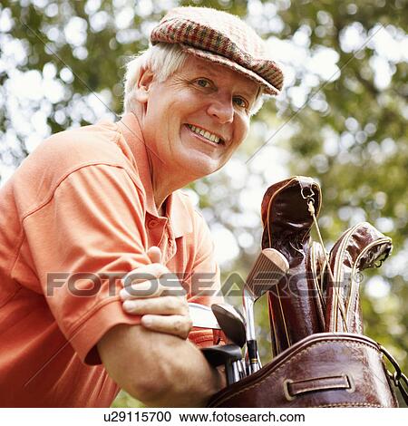 Portrait of a mature man leaning on a golf bag and smiling View Large Photo Image Stock Image - Portrait of a mature man leaning on a golf bag and smiling. Fotosearch