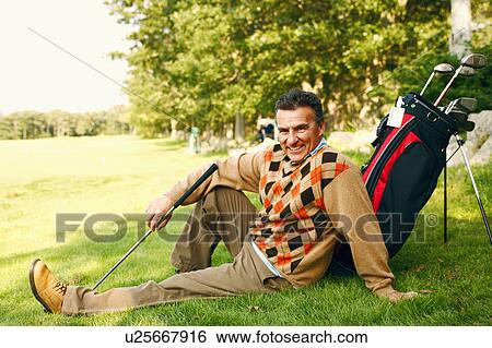 Portrait of a mature man sitting with a golf bag on a golf course View Large Photo Image Stock Photograph - Portrait of a mature man sitting with a golf bag on a golf course. Fotosearch