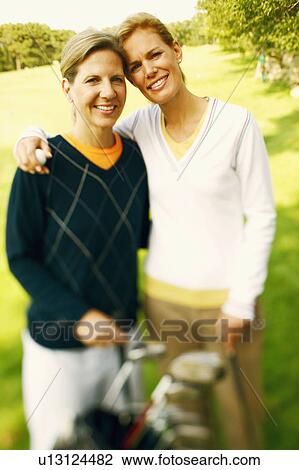 Portrait of a mid adult woman and a mature woman standing with a golf bag View Large Photo Image Stock Image - Portrait of a mid adult woman and a mature woman standing with a golf bag. Fotosearch