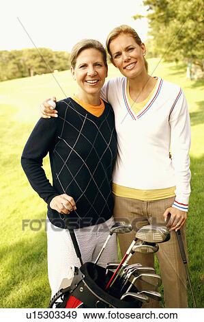 Portrait of a mid adult woman and a mature woman holding golf clubs View Large Photo Image Stock Photo - Portrait of a mid adult woman and a mature woman holding golf clubs. Fotosearch