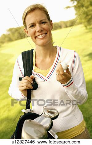 Portrait of a mid adult woman carrying a golf bag View Large Photo Image Stock Photograph - Portrait of a mid adult woman carrying a golf bag. Fotosearch