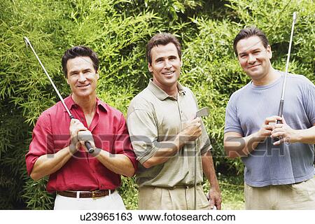 Three mature men holding golf clubs and smiling View Large Photo Image Stock Image - Three mature men holding golf clubs and smiling. Fotosearch
