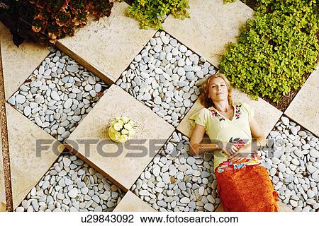High angle view of a mature woman lying in a garden View Large Photo Image Stock Image - High angle view of a mature woman lying in a garden. Fotosearch