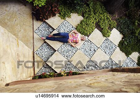 Picture - High angle view of a senior woman lying in a garden. Fotosearch