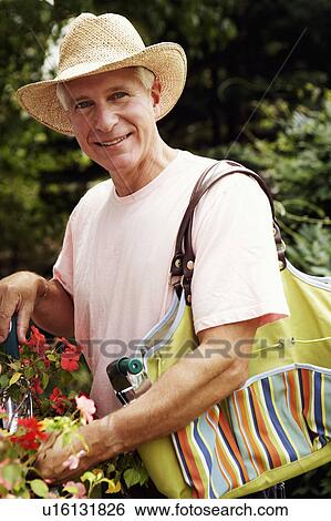 Stock Photograph - Portrait of a mature man gardening and smiling. Fotosearch