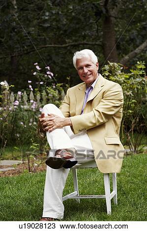 Portrait of a mature man sitting on a chair View Large Photo Image Stock Image - Portrait of a mature man sitting on a chair. Fotosearch