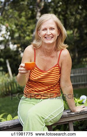 Portrait of a mature woman holding a cup View Large Photo Image Stock Photography - Portrait of a mature woman holding a cup. Fotosearch