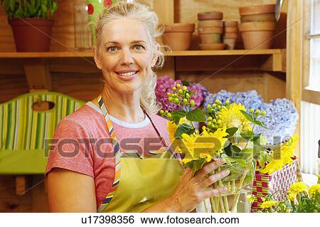 Stock Photograph - Portrait of a mature woman holding a vase. Fotosearch
