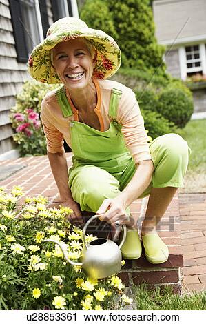 Portrait of a senior woman watering plants and smiling View Large Photo Image Stock Image - Portrait of a senior woman watering plants and smiling. Fotosearch