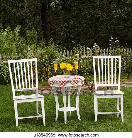 Two chairs and a table in a garden View Large Photo Image Stock Photography - Two chairs and a table in a garden. Fotosearch