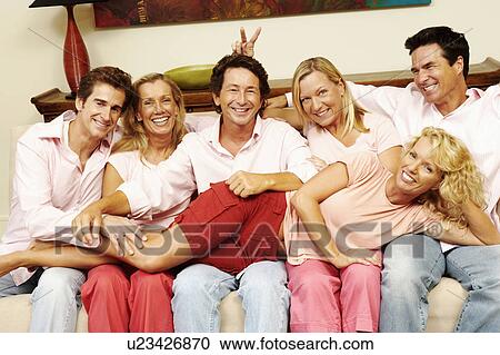 Close Up Of A Group Of People Sitting Together On A Couch Stock
