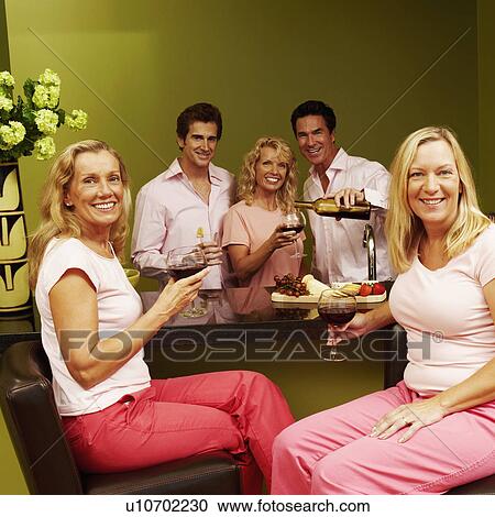 Portrait of a group of people at a kitchen counter and holding glasses of wine View Large Photo Image Stock Image - Portrait of a group of people at a kitchen counter and holding glasses of wine. Fotosearch