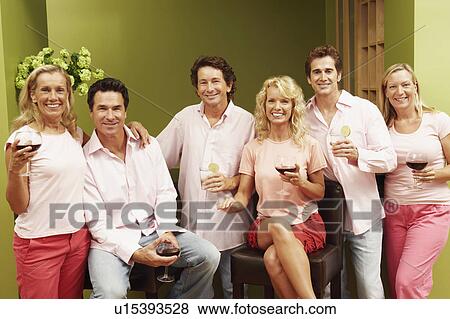 Portrait of a group of people at a kitchen counter and holding glasses of wine View Large Photo Image Stock Photo - Portrait of a group of people at a kitchen counter and holding glasses of wine. Fotosearch