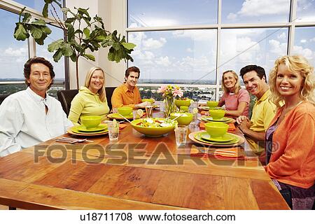 Stock Photo - Portrait of a group of people sitting at a dining table. Fotosearch