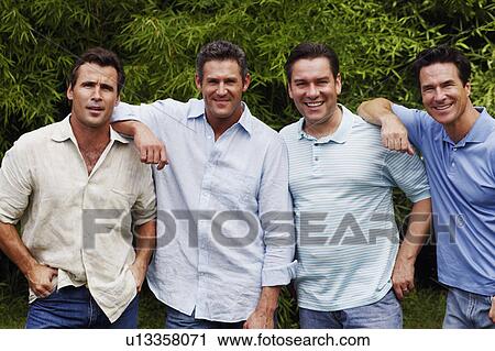 Stock Image - Portrait of a mid adult man with three mature men posing and smiling. Fotosearch